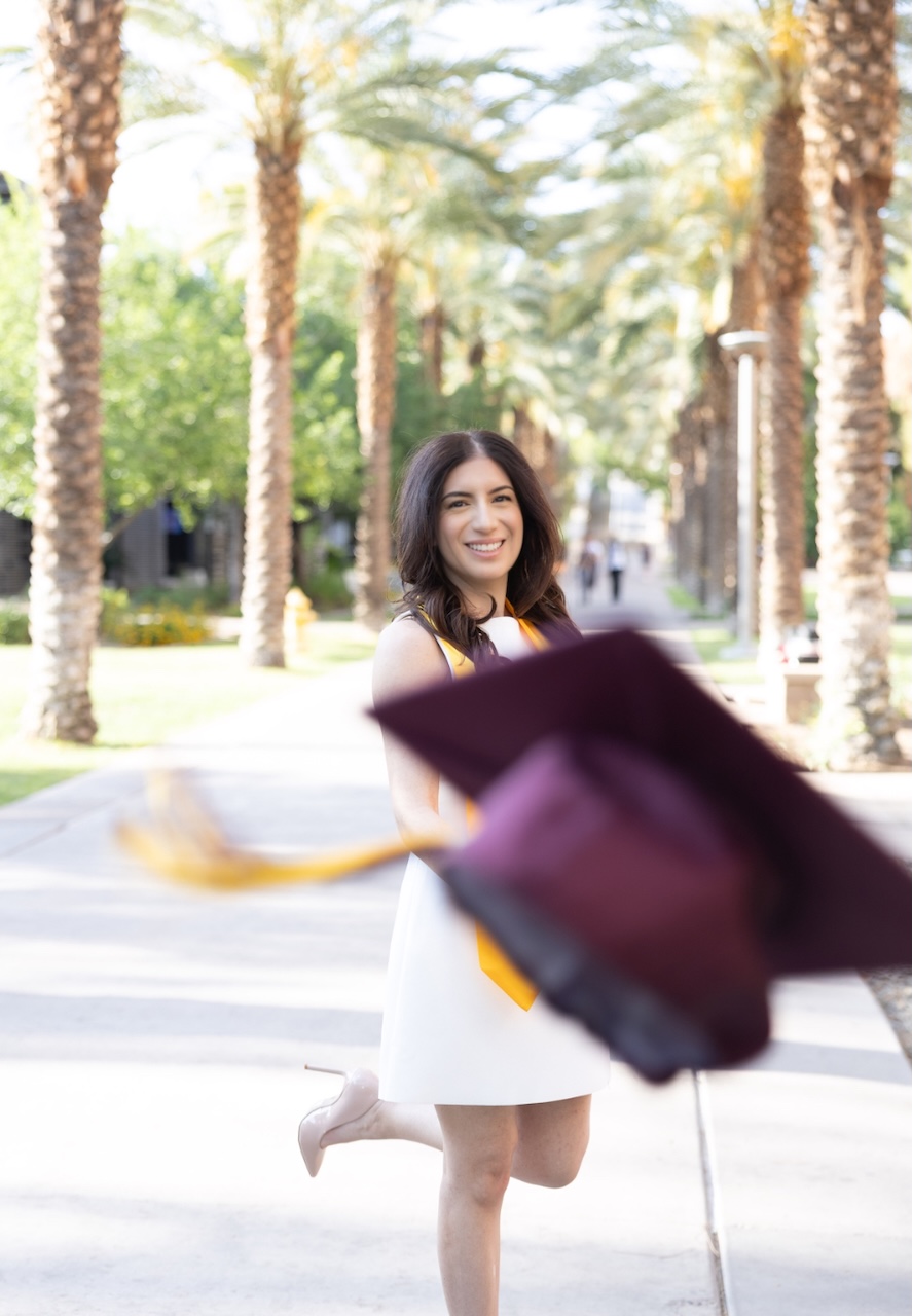 Online MACC graduate Natalie Goudarzian tosses her graduation cap at the camera for a photo
