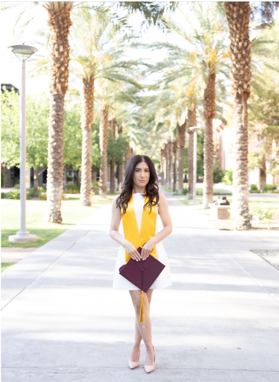 Online MACC graduate Natalie Goudarzian poses with graduation gear on ASU's Palm Walk