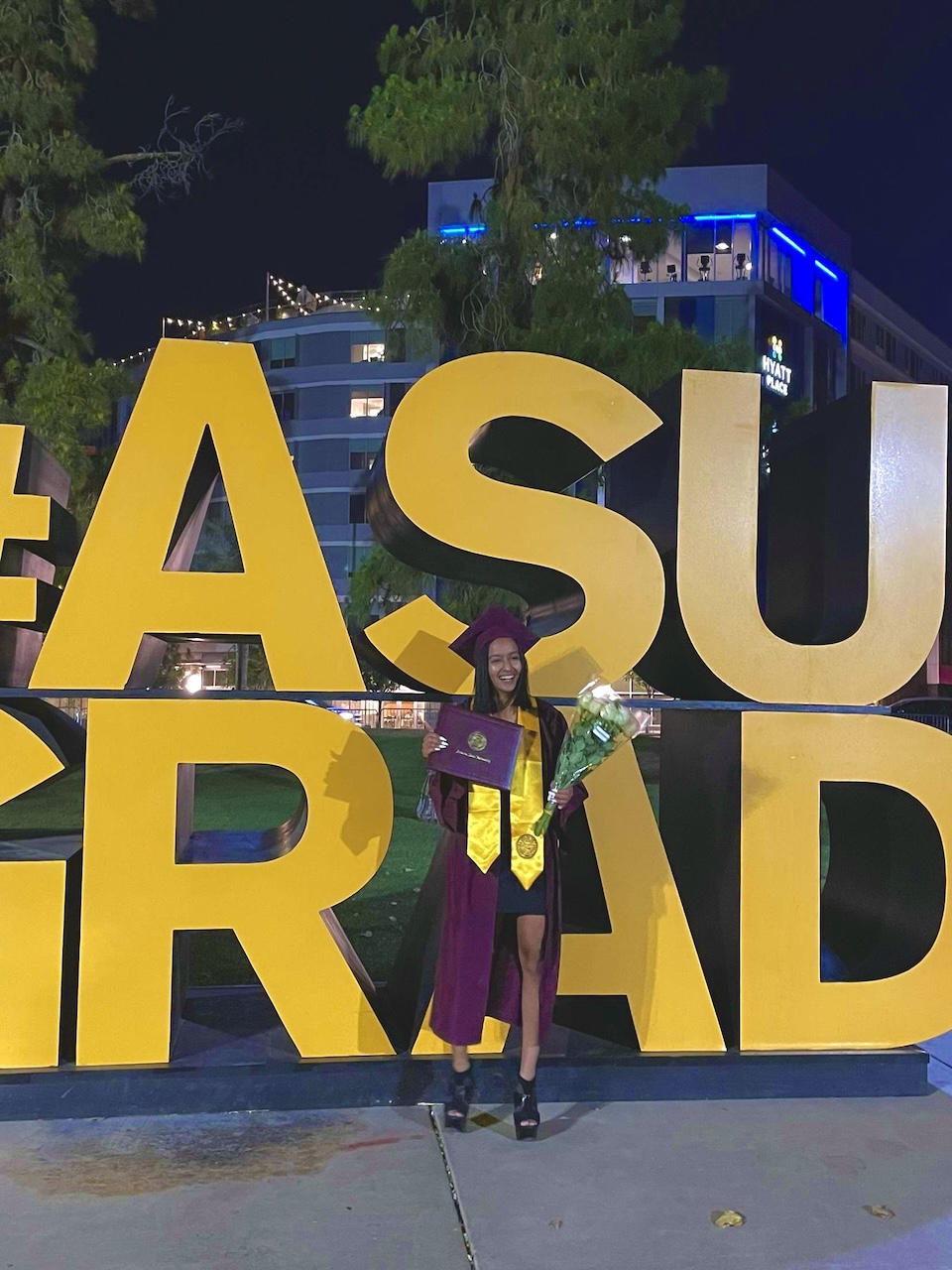 Business data analytics alum Paridhi Saboo poses in front of an ASU graduation sign in graduation gear